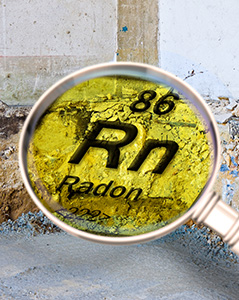 A magnifying glass focuses on the symbol for radon (Rn) from the periodic table, highlighting the atomic number 86. The background shows a concrete foundation wall, suggesting the context of radon inspection or testing in a building.